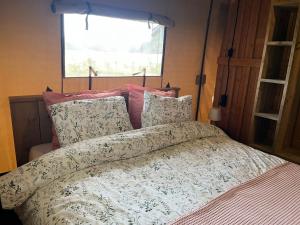 a bedroom with a bed with a comforter and pillows at Vakantieboerderij Den Deter in Meddoo