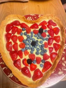 a pie with strawberries and blueberries in the shape of a heart at Al Vicolo in Telve +15 photos