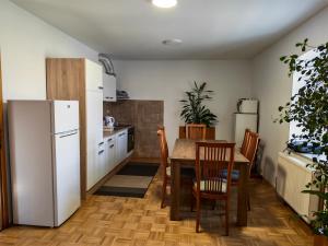 a kitchen with a table and a white refrigerator at Center Grič - sobe, apartma in Sveta Trojica v Slovenskih Goricah