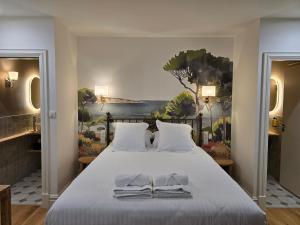 a bedroom with a bed with towels on it at Hôtel Le Groom in Laprade