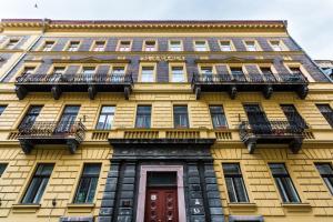 Un edificio amarillo con balcones y una puerta roja. en Urbana Hipster Downtown Budapest, en Budapest