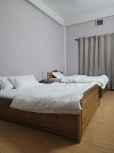 two twin beds in a bedroom with at Aama Ghar Siliguri in Siliguri