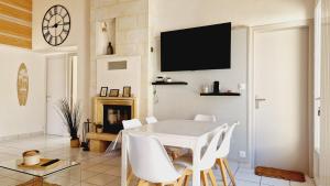 a dining room with a white table and white chairs at Le Rivage, maison proche mer avec Spa in Les Sables-d'Olonne +17 photos