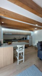 a kitchen with a counter and a white chair in a room at Casa da Fraga in Soajo