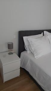 a bed with a nightstand next to a white bed at Casa da Fraga in Soajo