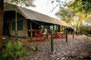 a tent with tables and chairs in a garden at Kirawira Serena Camp in Handajega