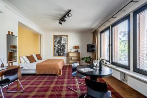 a hotel room with a bed and a table and chairs at A Place Antwerp - Boutique Suites & Flats - Vrijdagmarkt 1 in Antwerp