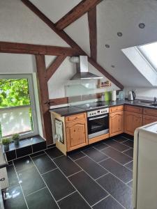 a kitchen with wooden cabinets and a stove top oven at Ferienwohnung Moos in Haiger