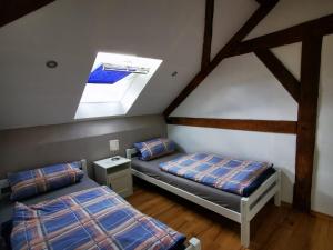 two beds in a attic room with a skylight at Ferienwohnung Moos in Haiger
