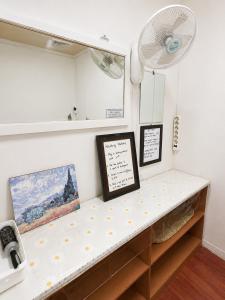 a room with a shelf with paintings and a fan at 신사 여성전용 개인 미니룸 Female Only Private Mini Room Gosiwon 2pm ckeck in 11am ckeck out address 강남구 논현동6-8 BESTEL, Check the message for the check in in Seoul +27 photos