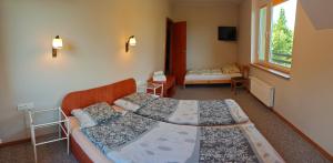 a bedroom with two beds and a window at Mazury całoroczny dom do wynajęcia nad jeziorem Sasek Wielki in Pasym