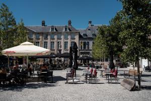 a group of tables and chairs with umbrellas in a courtyard at A Place Antwerp - Boutique Suites & Flats - Vrijdagmarkt 1 in Antwerp