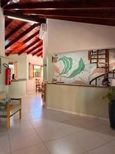 a lobby with a wall with a painting of a lizard at Pousada Morada da Praia - Ubatuba -Praia Grande in Ubatuba