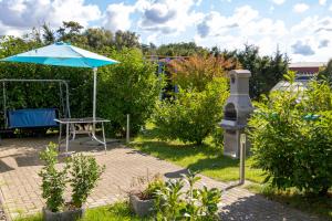 a table and an umbrella in a garden at Bungalow am Waldrand in Barth