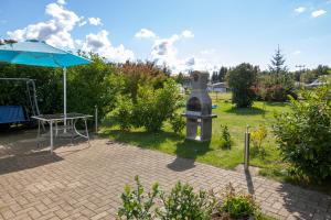 a patio with a table and an umbrella at Bungalow am Waldrand in Barth +2 photos