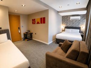 a hotel room with two beds and a couch at Taksim REXEE Istanbul Istiklal Hotel in Istanbul +51 photos