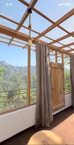 a room with a large window with a view at Nivriti Stays in Nainital