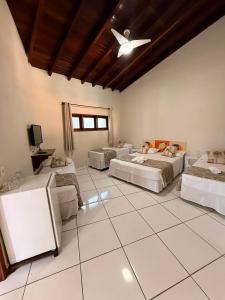 a room with four beds and a ceiling fan at Pousada Morada da Praia - Ubatuba -Praia Grande in Ubatuba