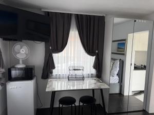 a kitchen with a table and two stools in front of a window at Mieszkanie Ratownika in Dziwnów