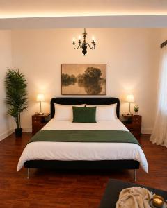 a bedroom with a large bed and a chandelier at Casa do Jardim in Peniche