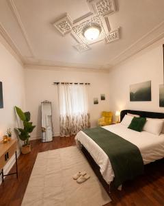 a bedroom with a large bed with a green blanket at Casa do Jardim in Peniche