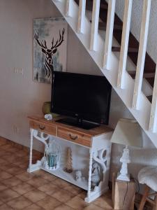 a television sitting on a table under a staircase at Hameau des Granges in Bourisp +31 photos