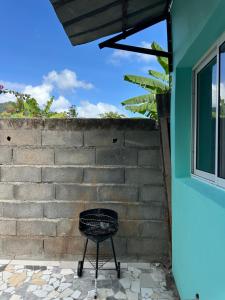 a black chair sitting next to a brick wall at Ouzouri Wa Lijou in Mzouazia
