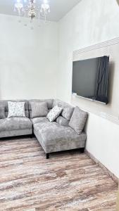 a living room with a couch and a flat screen tv at شقة استديو in Al Baha
