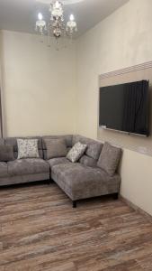 a living room with a couch and a flat screen tv at شقة استديو in Al Baha
