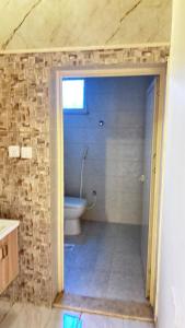 a bathroom with a toilet and a stone wall at شقة استديو in Al Baha