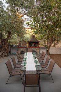 a long table with chairs and a table with cups at vranas hotel in Skala Sotiros