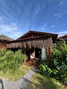 a house with a thatch roof at Pousada Rosa Astral ॐ in Praia do Rosa