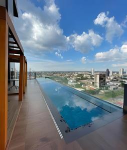 a swimming pool on the roof of a building with a view at Vertigo Premium Studios in Campo Grande