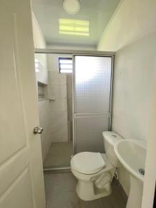 a white bathroom with a toilet and a sink at Apartamentos El Remanso in Mariquita