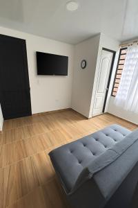 a living room with a couch and a flat screen tv at Apartamentos El Remanso in Mariquita