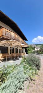 a building with tables and umbrellas in front of it at Gasthof Zur Sonne in Laion
