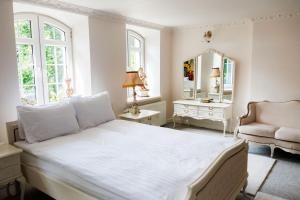 a bedroom with a bed and a chair and a mirror at Dwór Lisewo in Lisewo