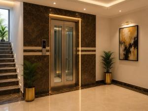 a lobby with a door and stairs with plants at IndiGo Line Hotel - Opp Paradise Biryani Shamshabad in Hyderabad