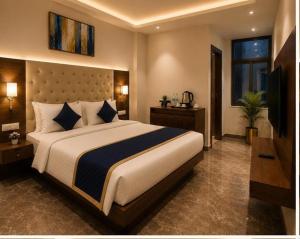 a bedroom with a large bed and a television at IndiGo Line Hotel - Opp Paradise Biryani Shamshabad in Hyderabad