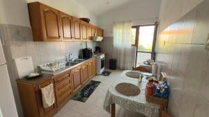 a kitchen with wooden cabinets and a table in it at Markella STONE & LIGHT Skoutari-Mani in Skoutari
