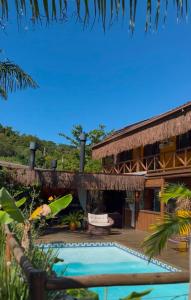 a resort with a swimming pool and a building at Pousada Rosa Astral ॐ in Praia do Rosa