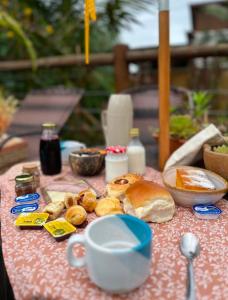 a table topped with bread and a cup of coffee at Pousada Rosa Astral ॐ in Praia do Rosa +64 photos