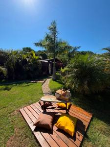 a picnic table with pillows on a wooden deck at Pousada Rosa Astral ॐ in Praia do Rosa