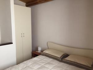 シラクーサにあるArchè Holiday Houseの小さなベッドルーム(ベッド1台、キャビネット付)