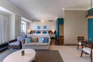 a hotel room with a bed and a couch and a table at Hotel Deville Prime Salvador in Salvador +91 photos