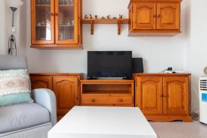 a living room with a couch and a tv on a cabinet at Apt Italia 96 in Almarda