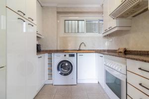 a white laundry room with a washer and dryer at Apt Italia 96 in Almarda