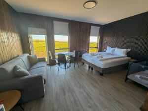 a bedroom with a bed and a couch and a table at Myrkholt Cabin in Tungufell