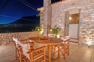 a dining room with a wooden table and chairs at Melias Olive Retreat in Kelefá