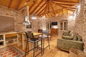 a kitchen and living room with a stone wall at Melias Olive Retreat in Kelefá